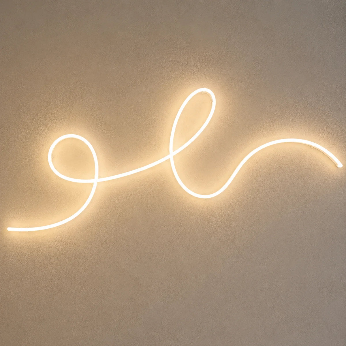 Néon LED blanc chaud en écriture cursive installé sur un mur d'enduit clair, fixations apparentes